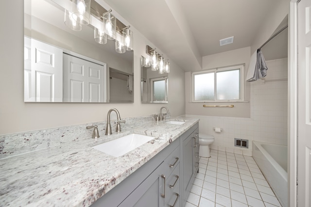 bathroom with tile walls, visible vents, and a sink