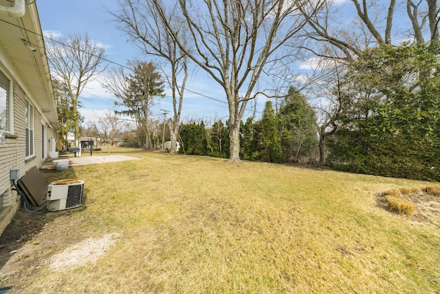 view of yard with central air condition unit and a patio area