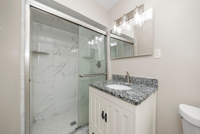 full bath with toilet, vanity, and a marble finish shower