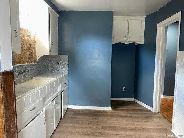 19533 Barlow St, Detroit, MI 48205 - kitchen featuring white cabinetry, light wood finished floors, and light countertops