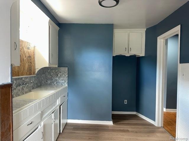 19533 Barlow St, Detroit, MI 48205 - kitchen featuring light wood-type flooring, white cabinets, and light countertops