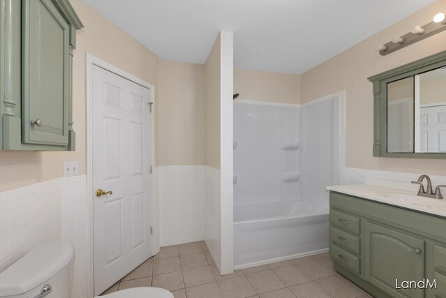 2206 Woodward Ave, Kalamazoo, MI 49007 - bathroom featuring tile patterned flooring, vanity, tile walls, toilet, and a wainscoted wall