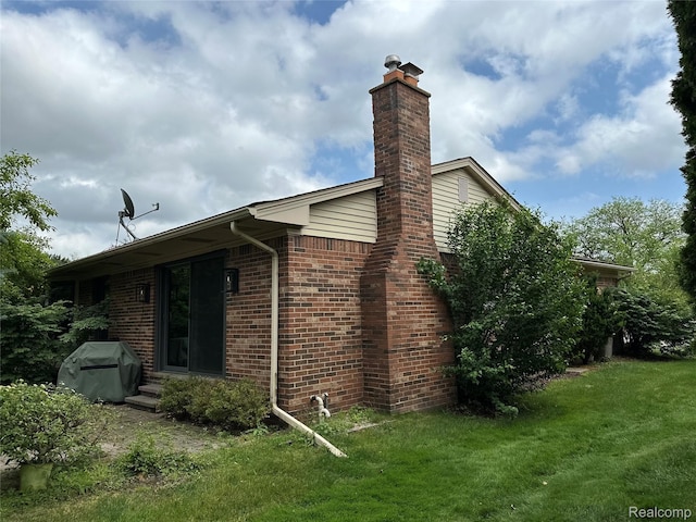 17018 White Haven Dr, Northville, MI 48168 - view of side of home featuring a chimney, brick siding, and a lawn