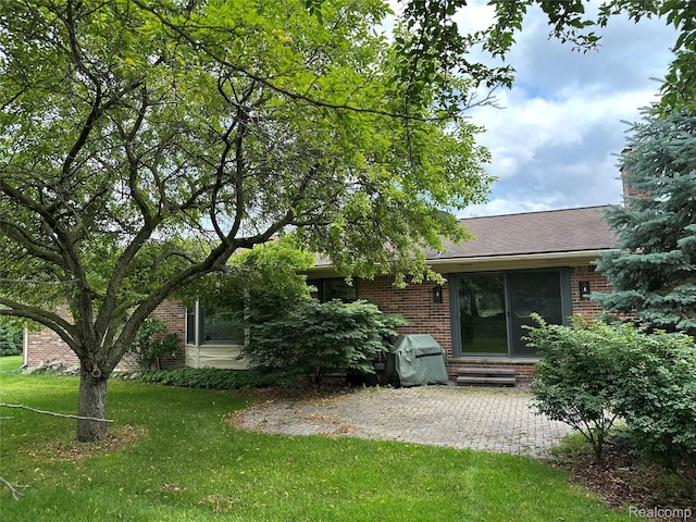 17018 White Haven Dr, Northville, MI 48168 - back of house with brick siding, a lawn, a patio, and a shingled roof