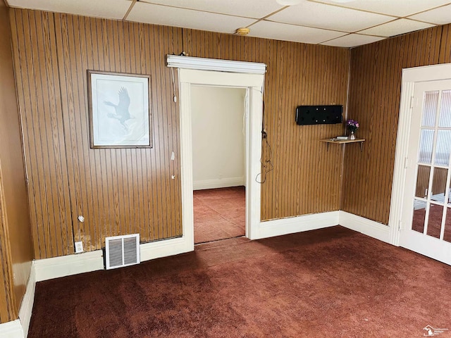 1073-1075 Morrell St, Detroit, MI 48209 - carpeted empty room featuring a paneled ceiling, wooden walls, baseboards, and visible vents