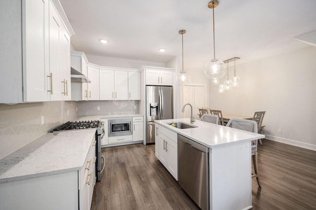 kitchen featuring a kitchen breakfast bar, stainless steel appliances, backsplash, extractor fan, and white cabinets