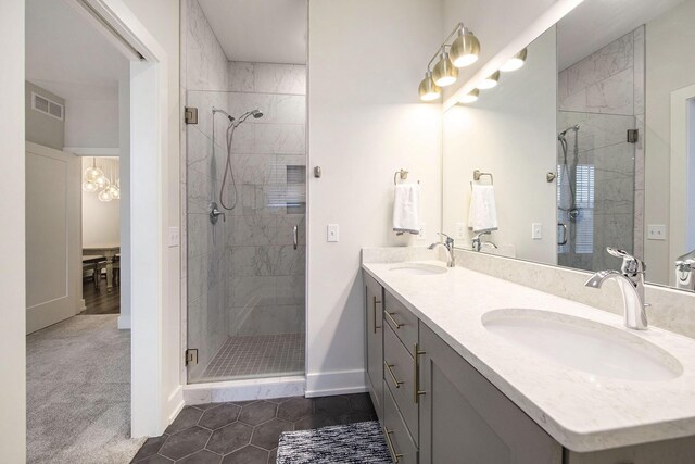 full bath featuring a shower stall, baseboards, visible vents, and a sink