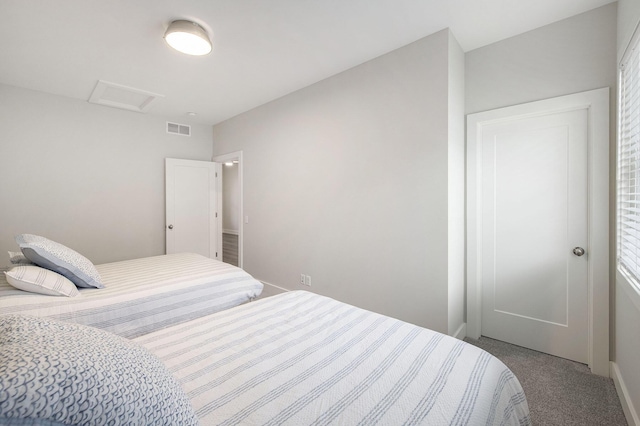 carpeted bedroom featuring visible vents and attic access