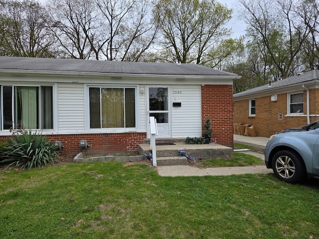 2046 Stieber St, Westland, MI 48186 - view of front of home with entry steps, a front yard, and brick siding