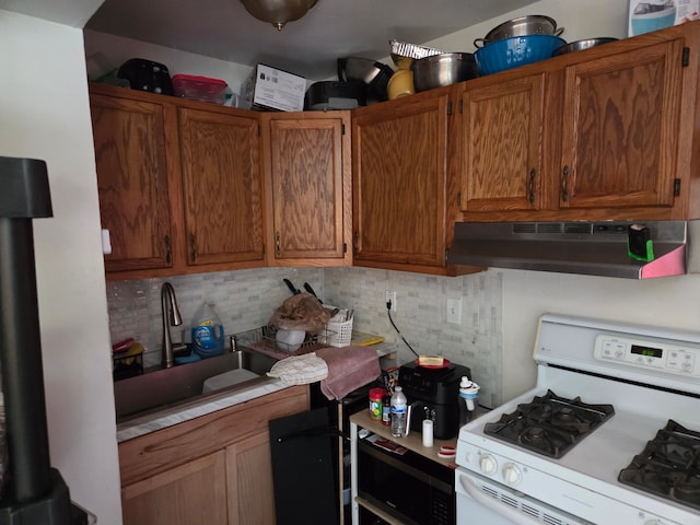 2046 Stieber St, Westland, MI 48186 - kitchen featuring decorative backsplash, white gas stove, light countertops, a sink, and under cabinet range hood