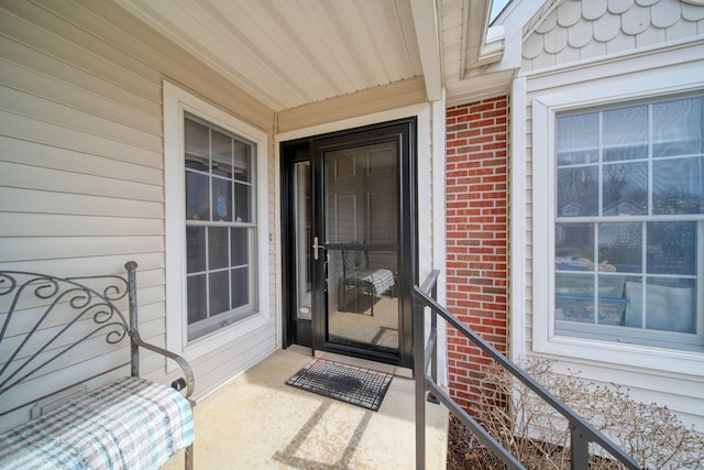 doorway to property featuring brick siding