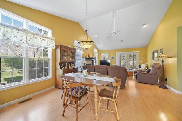dining area featuring high vaulted ceiling, a ceiling fan, baseboards, visible vents, and light wood-style floors