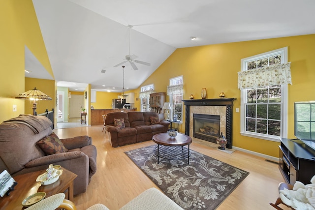 living area featuring plenty of natural light, high vaulted ceiling, wood finished floors, and ceiling fan