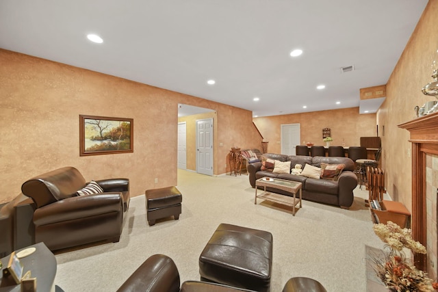carpeted living area featuring a fireplace, visible vents, and recessed lighting