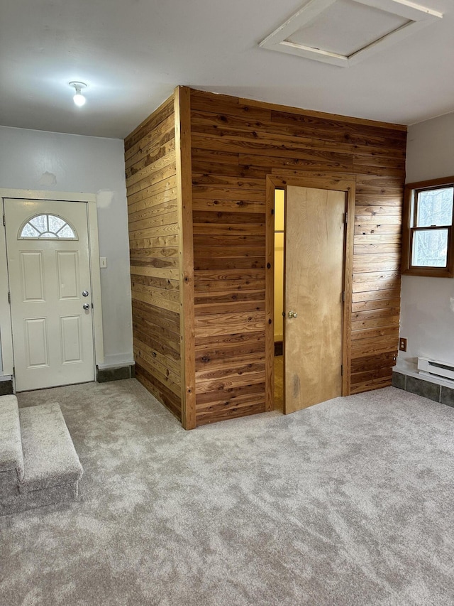 entryway with wood walls, carpet flooring, and a baseboard heating unit