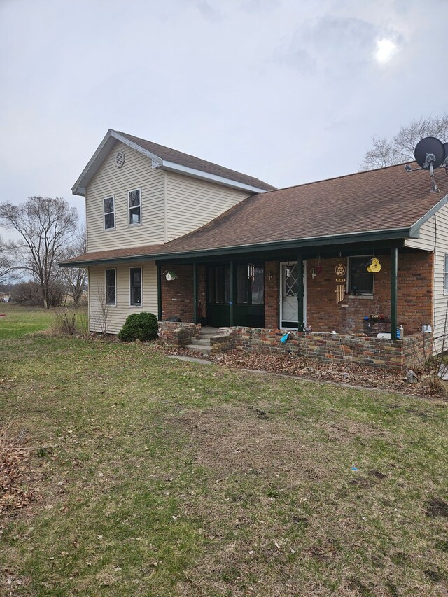 4950 Cottrell Rd, Vassar, MI 48768 - view of front of home with a front lawn, covered porch, brick siding, and roof with shingles