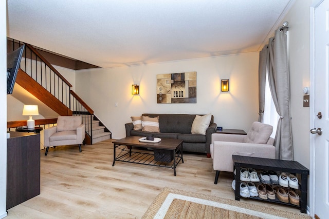 living area with stairs and wood finished floors
