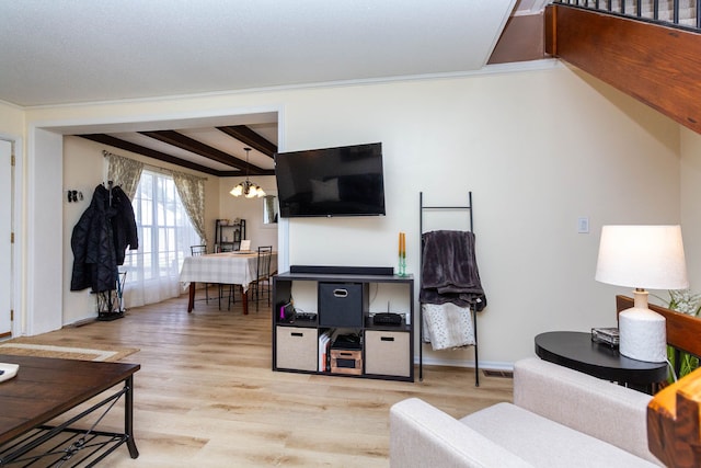 living room with crown molding, a chandelier, wood finished floors, baseboards, and beam ceiling