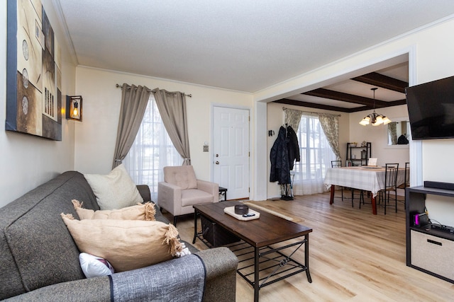 living area featuring a chandelier, a textured ceiling, beamed ceiling, and light wood-style flooring
