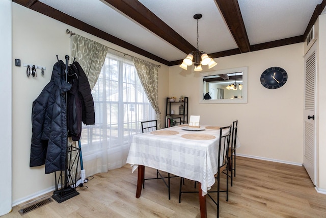 dining area with visible vents, baseboards, a notable chandelier, beamed ceiling, and wood finished floors