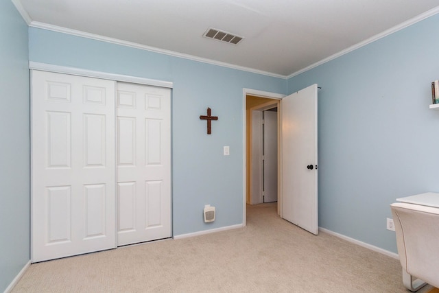 unfurnished bedroom with a closet, baseboards, carpet flooring, crown molding, and visible vents