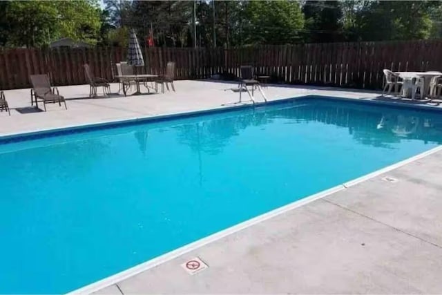 view of swimming pool featuring fence, a patio area, and a fenced in pool