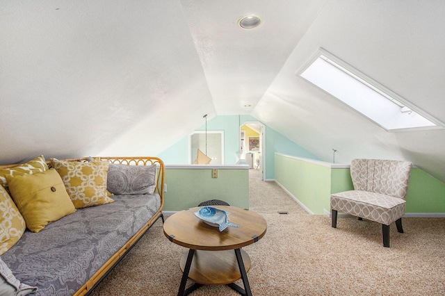 interior space featuring baseboards, vaulted ceiling with skylight, and carpet flooring