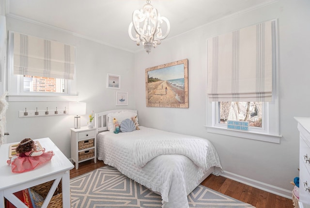 bedroom featuring a chandelier, wood finished floors, baseboards, and ornamental molding
