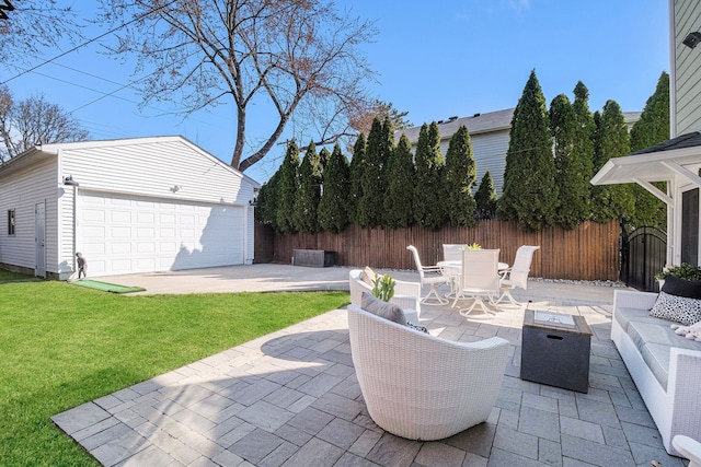 view of patio / terrace with an outdoor structure, a detached garage, an outdoor living space with a fire pit, outdoor dining area, and fence