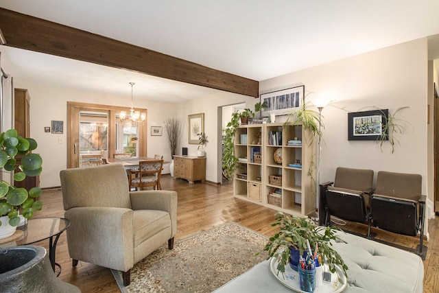 living room with wood finished floors, beam ceiling, and a chandelier