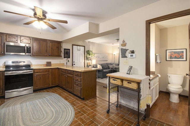 kitchen with open floor plan, light countertops, appliances with stainless steel finishes, and a peninsula