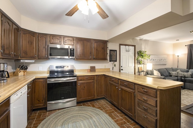 kitchen featuring open floor plan, light countertops, a peninsula, and appliances with stainless steel finishes