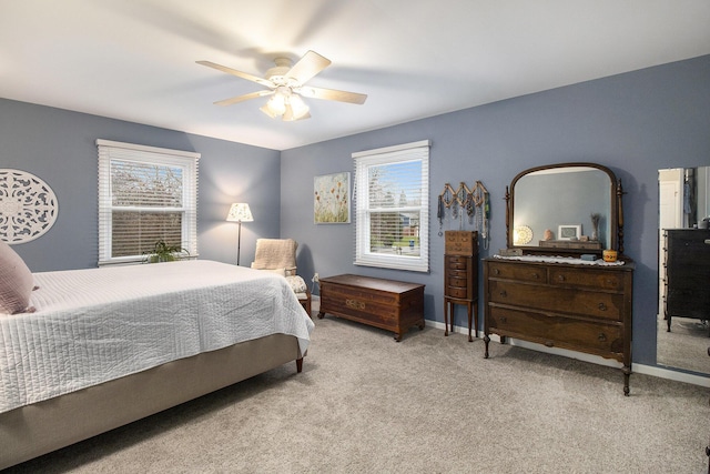 bedroom with carpet floors, baseboards, multiple windows, and ceiling fan