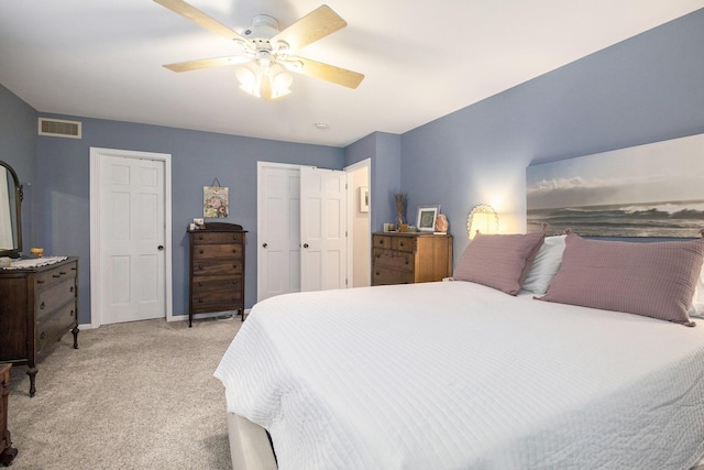 bedroom featuring light carpet, baseboards, visible vents, and a ceiling fan