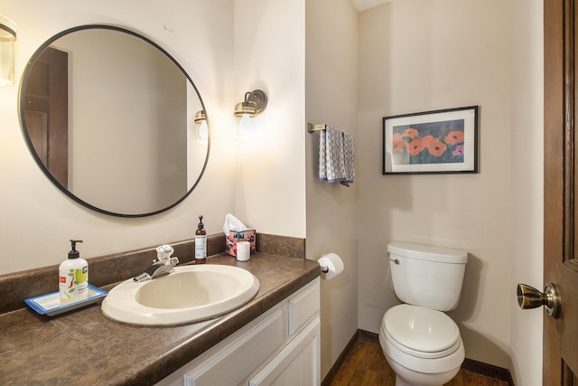 bathroom with baseboards, toilet, vanity, and wood finished floors