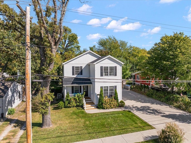traditional-style home featuring driveway, a front yard, and fence