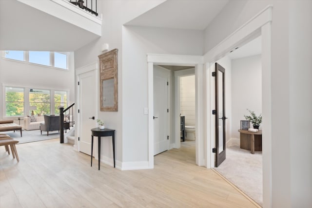 50272 Hedgewood Dr, Canton, MI 48187 - corridor featuring light wood finished floors, stairs, a high ceiling, and baseboards