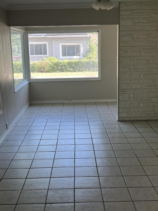unfurnished room with light tile patterned floors, a ceiling fan, and crown molding