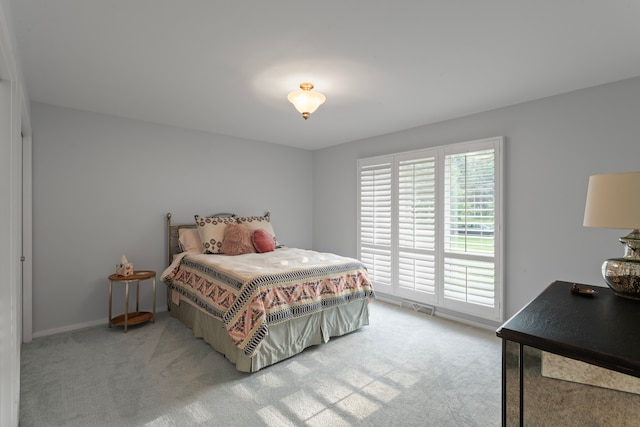 bedroom featuring baseboards and light carpet