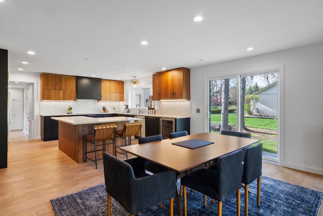 dining room with recessed lighting, light wood-style flooring, and wine cooler