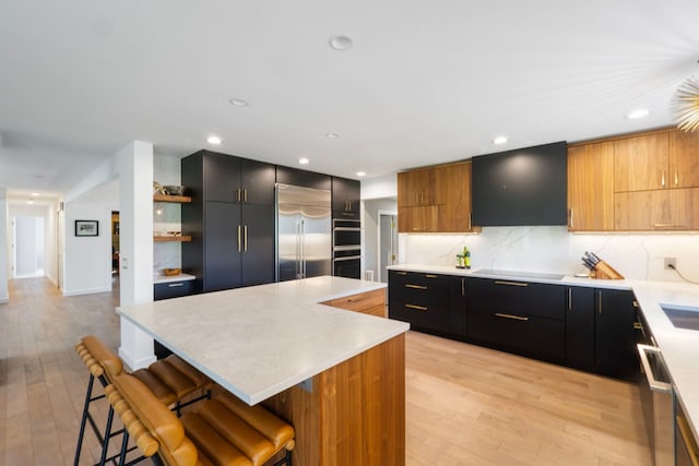 kitchen with light countertops, stainless steel appliances, modern cabinets, and a center island