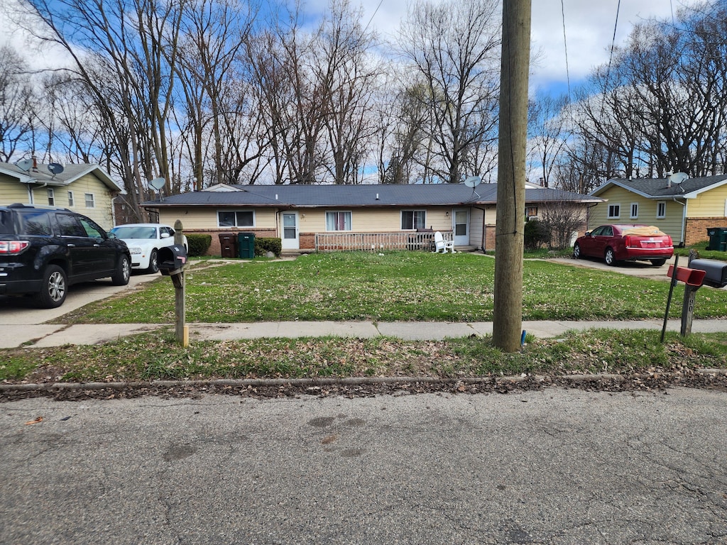 908/910 Pierce Rd, Lansing, MI 48910 - view of front facade with brick siding, driveway, and a front lawn