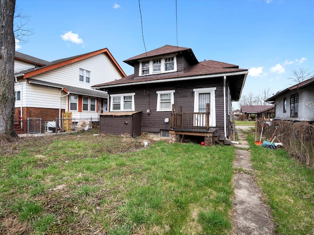 rear view of property featuring central AC unit, fence, a lawn, and roof with shingles