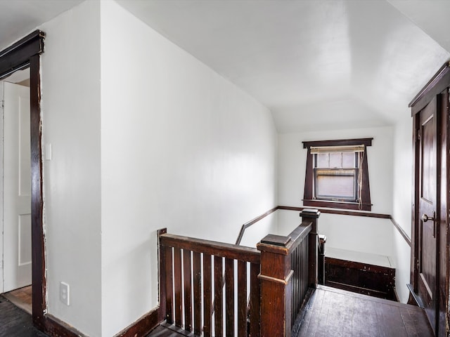 staircase featuring wood-type flooring and lofted ceiling