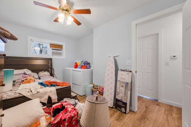 bedroom featuring cooling unit, light wood-style flooring, washer and dryer, and a ceiling fan