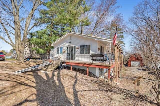 view of front of home featuring a wooden deck, an outdoor structure, and a garage