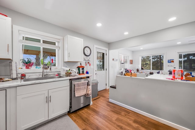 kitchen featuring white cabinets, light countertops, a sink, recessed lighting, and dishwasher