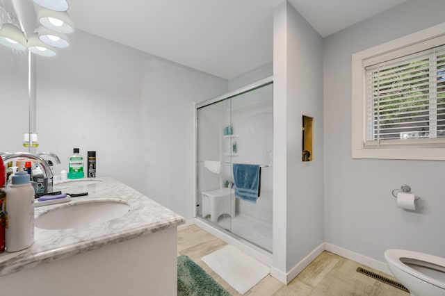 full bath with a sink, double vanity, a stall shower, toilet, and visible vents