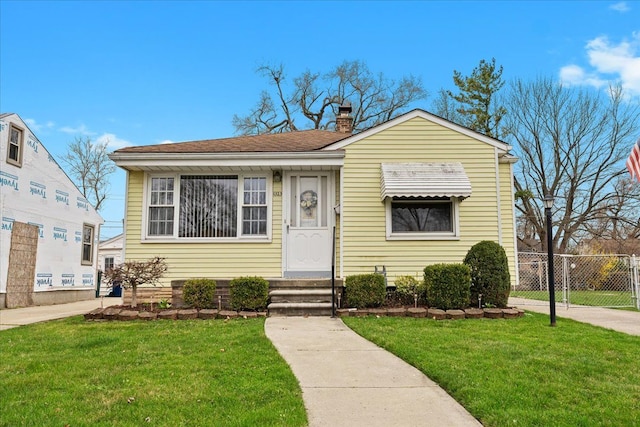 bungalow-style home featuring a front yard, fence, and a chimney
