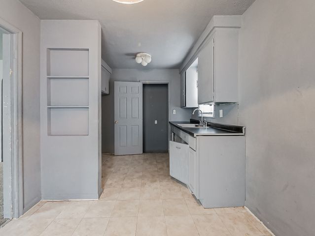 16665 San Juan Dr, Detroit, MI 48221 - kitchen with light tile patterned floors, white cabinetry, and a sink